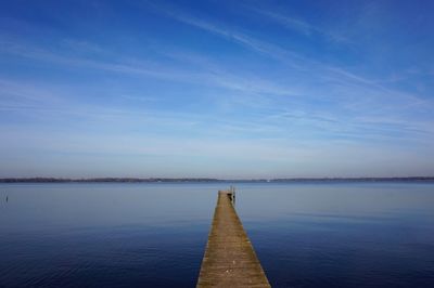 Pier over lake against blue sky