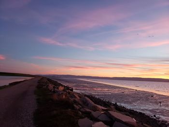 Scenic view of beach against sky during sunset