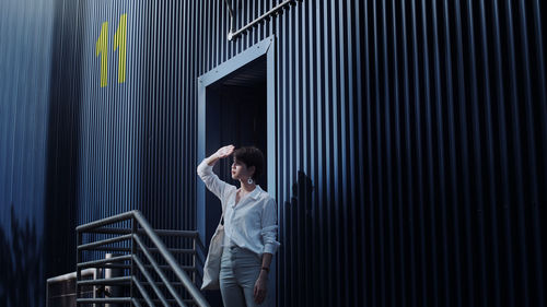 Woman shielding eyes while standing on steps