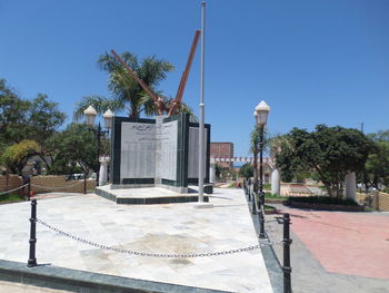 Built structure by trees against clear blue sky