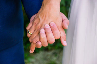 Midsection of couple holding hands