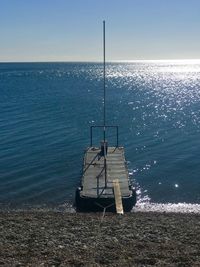 Fishing rod on sea against sky