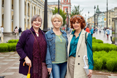 Portrait of smiling women standing in city