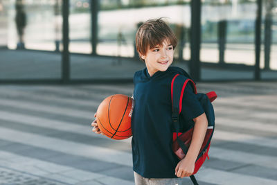 Portrait of smiling boy with ball in background