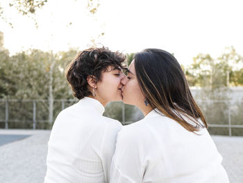 Affectionate lesbian couple with eyes closed kissing on mouth