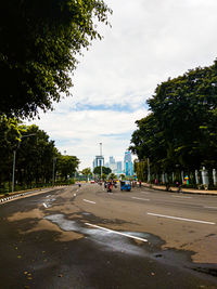 Cars on road in city against sky