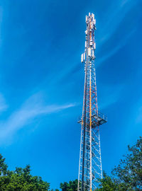 Low angle view of communications tower against blue sky