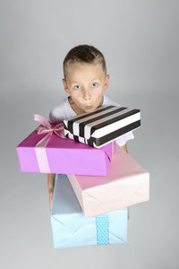 Portrait of boy holding paper against white background