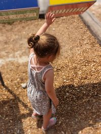 Rear view of girl playing on land