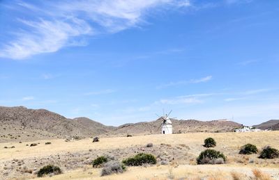 Scenic view of land against sky and an old windmill