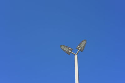 Low angle view of street light against blue sky