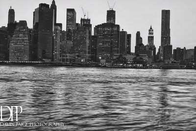 River by modern buildings in city against sky