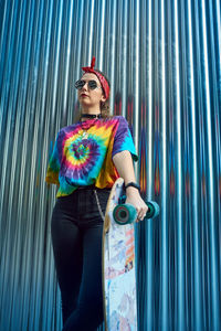 Young woman with urban style, she poses with a long board.