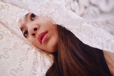Low angle view of thoughtful young woman in blanket