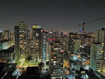 High angle view of illuminated buildings against sky at night