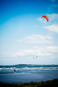 Man kiteboarding on sea against sky