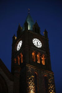 Low angle view of clock tower against blue sky