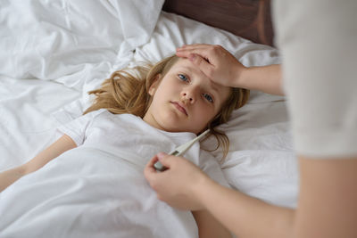 High angle view of woman lying on bed