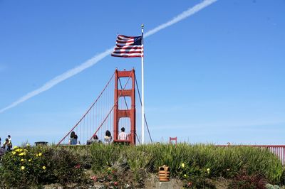 Golden gate bridge and american flag against blue sky