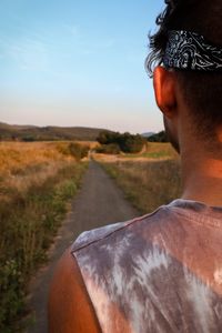 Rear view of man on road against sky during sunset