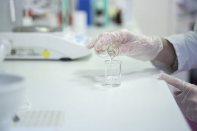 Hand of scientist mixing liquids at laboratory