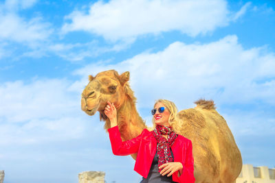 Woman with camel standing in city