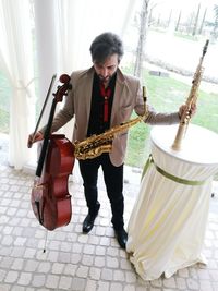 High angle view of musician with various musical instruments standing by table