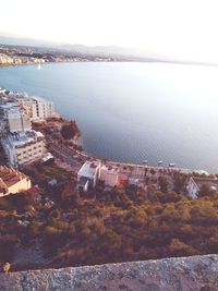 High angle view of townscape by sea against sky