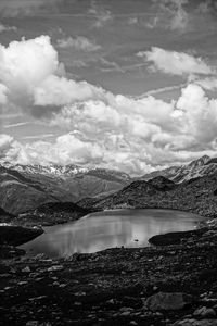 Scenic view of lake by mountains against sky