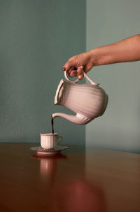 Someone pouring coffee into a cup. conceptual image