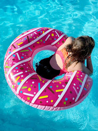 High angle view of child floating in swimming pool