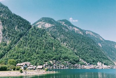 Scenic view of lake by mountains against sky