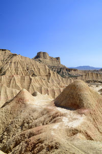 Rock formations in desert against clear blue sky