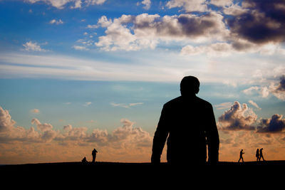 Rear view of silhouette man against sky during sunset