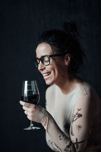 Portrait of smiling young woman drinking glass