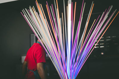 Rear view of man standing by multi colored decoration