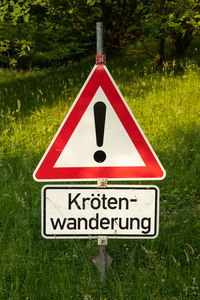 Close-up of road sign on field