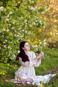 Young woman standing against plants