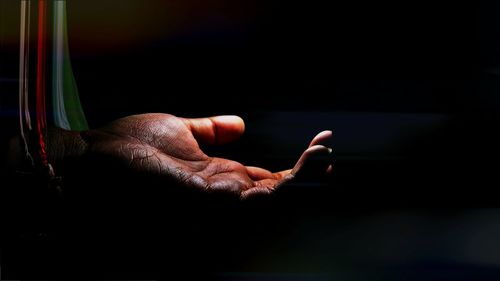 Close-up of hand against black background