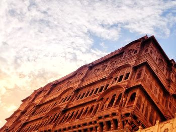 Low angle view of old building against cloudy sky