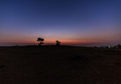 Scenic view of silhouette field against sky at sunset