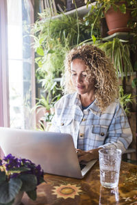 Portrait of young woman using laptop at table