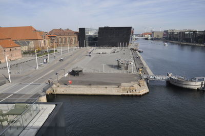 High angle view of city by river against sky