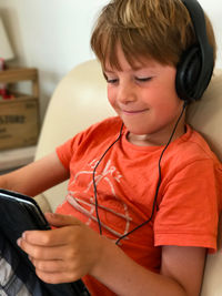 Cute boy using mobile phone at home
