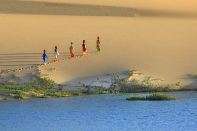 Women walking on desert by sea