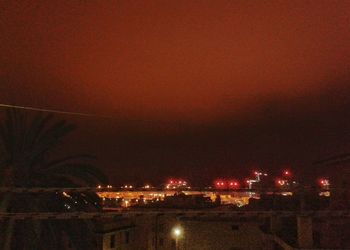 High angle view of illuminated buildings against sky at night