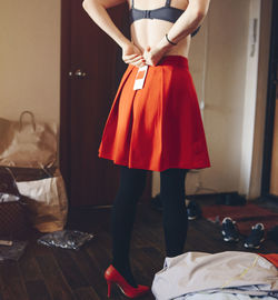 Rear view of woman wearing skirt while standing at home