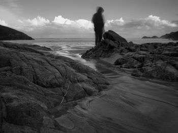 Scenic view of rocks on beach against sky