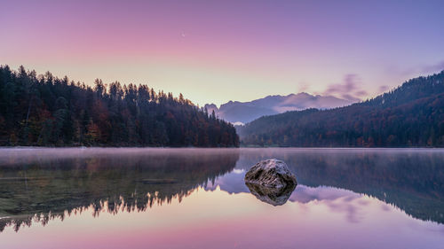 Reflection of trees in lake against sky during sunset