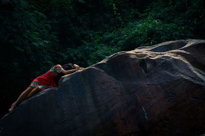 Woman on rock in forest